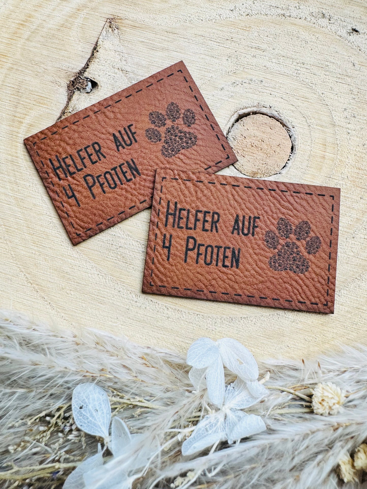 braunes Kunstlederlabel mit dem Spruch Helfer auf 4 Pfoten und einer Tatze abgebildet