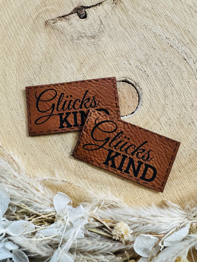 superweiches braunes Kunstleder Label mit dem Spruch GlücksKind in schöner schwarzer Schrift