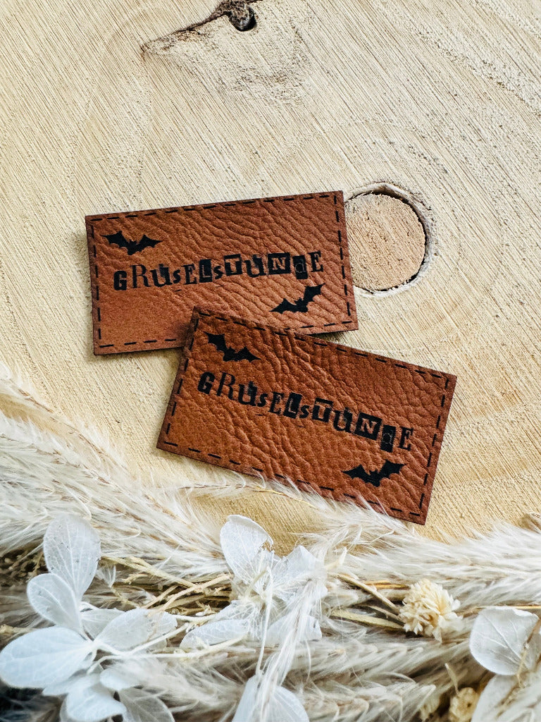 superweiches braunes Kunstleder Label mit dem Wort Gruselstunde und zwei kleinen Fledermäusen
