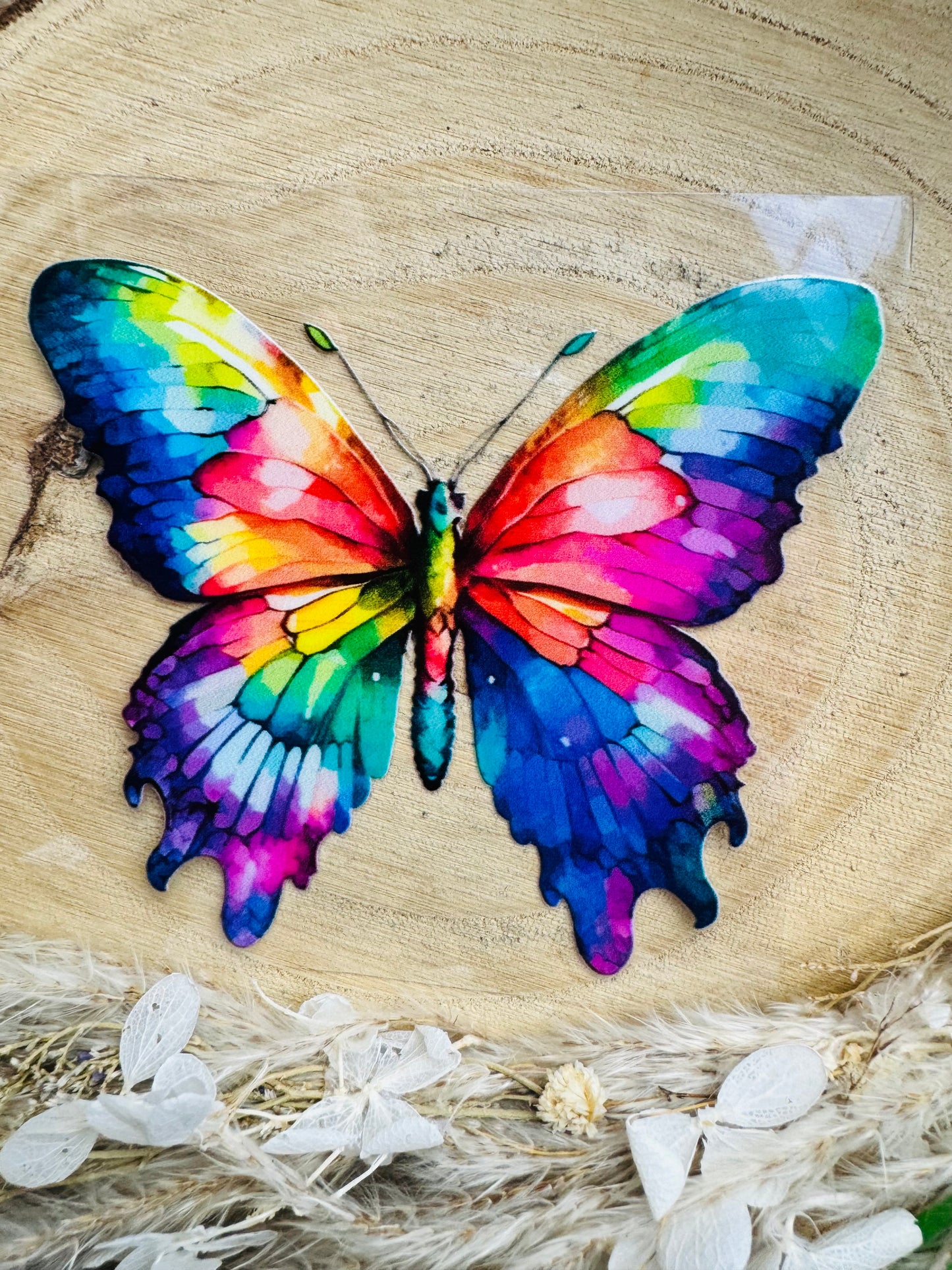 UV-Sticker mit einem Schmetterling mit ausgebreiteten Flügeln in regenbogen aquarell Farben