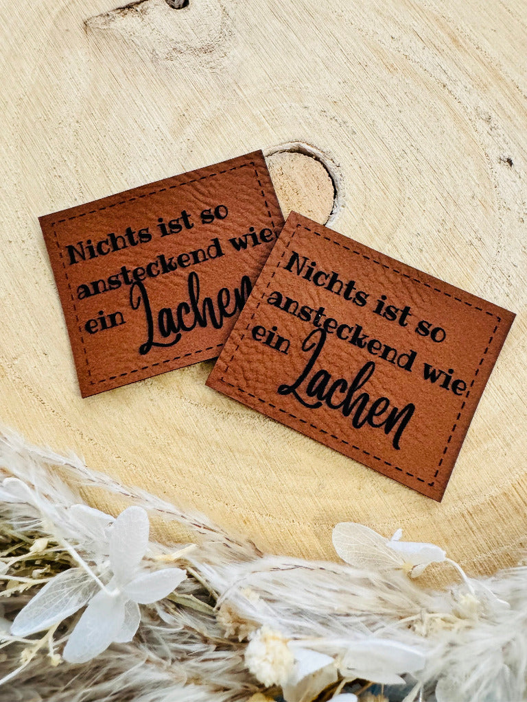 superweiches braunes Kunstlederlabel mit dem Spruch Nichts ist so ansteckend wie ein Lachen