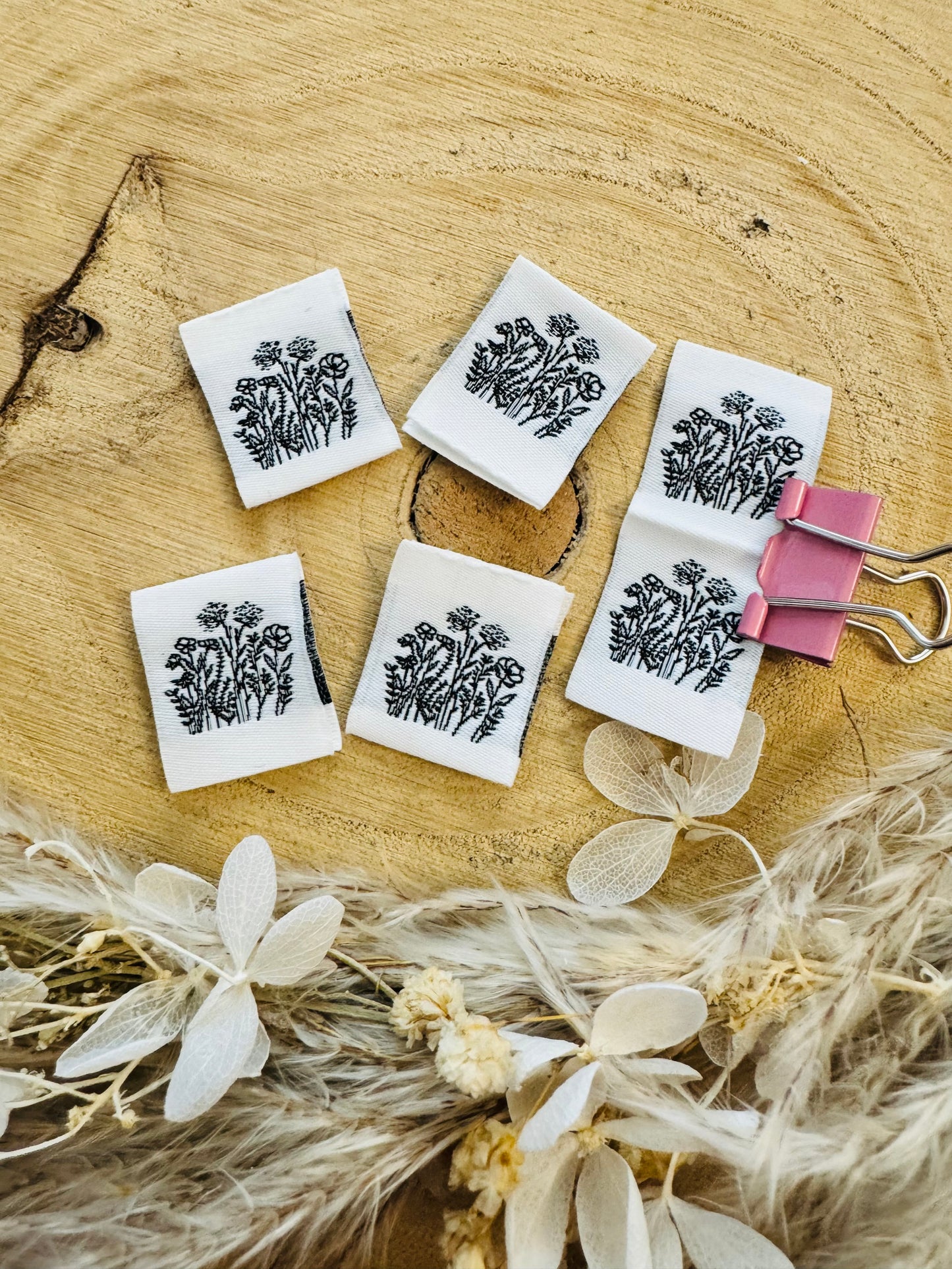 weisses Weblabel mit einer gezeichneten Blumenwiese in schwarzem Design
