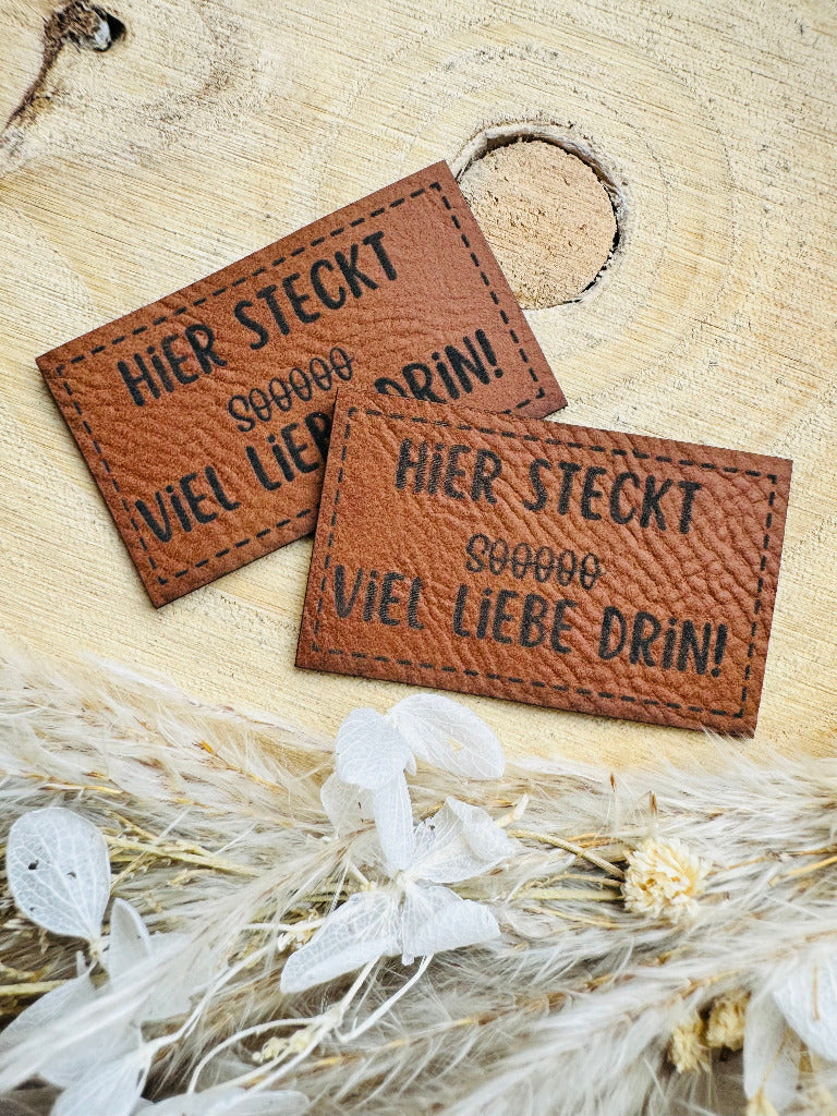 superweiches braunes Kunstlederlabel mit dem Spruch Hier stekt Soooo in Klammern Durchgestrichen viel Liebe drin Ausrufezeichen