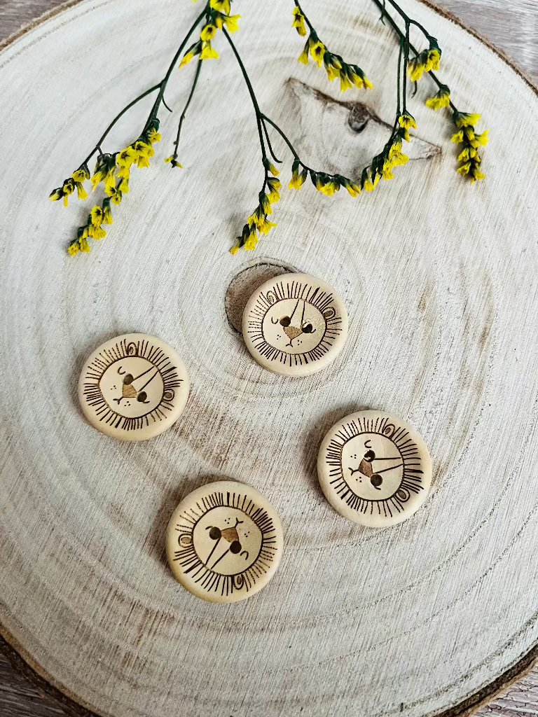 Holzknopf rund mit einem Löwenkopf abgebildet