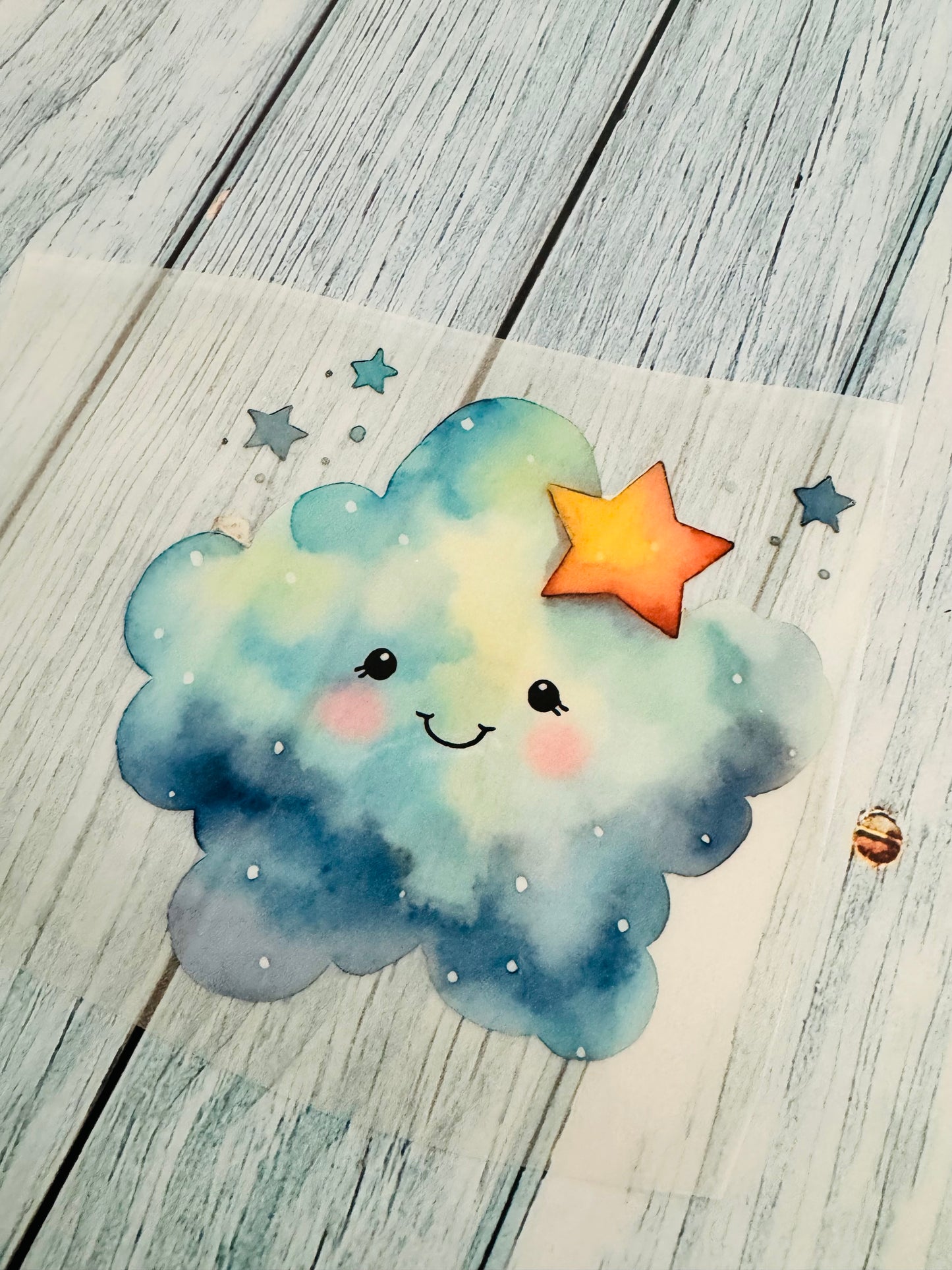 im Dunkeln leuchtendes Bügelbild mit einer kleinen Wolke in blauen Aquarellfarben mit einem rötlichen Stern