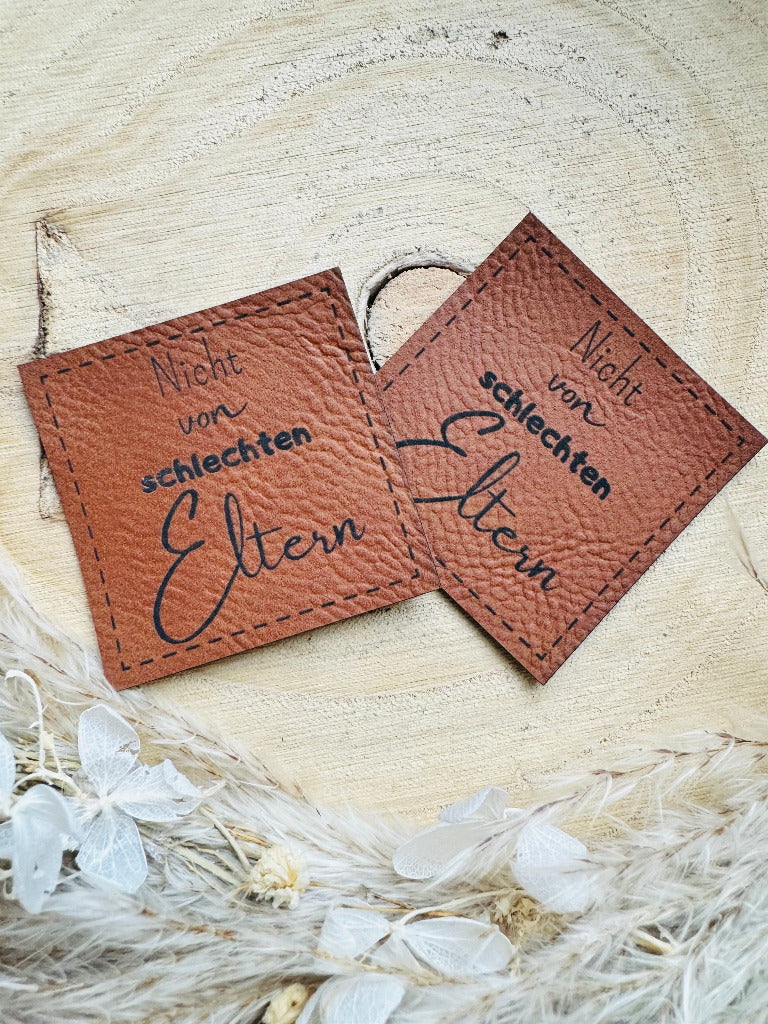 superweiches braunes Kunstlederlabel mit dem Spruch Nicht von schlechten Eltern in schwarzer Schrift