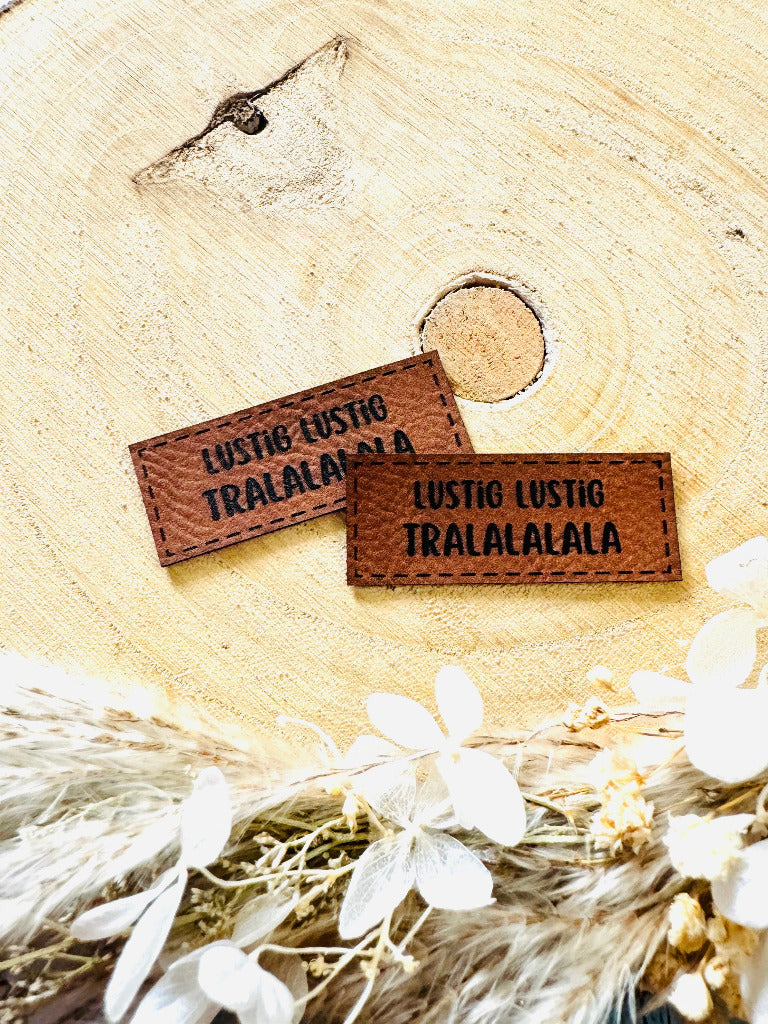 superweiches braunes Kunstlederlabel mit dem Spruch Lustig Lustig Tralalalala
