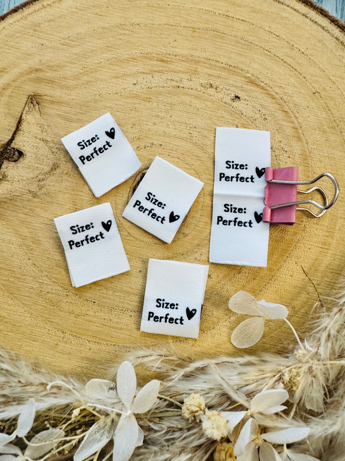 weisses Weblabel mit dem Spruch Size Doppelpunkt perfect in schwarzer Schrift mit einem kleinen Herzen