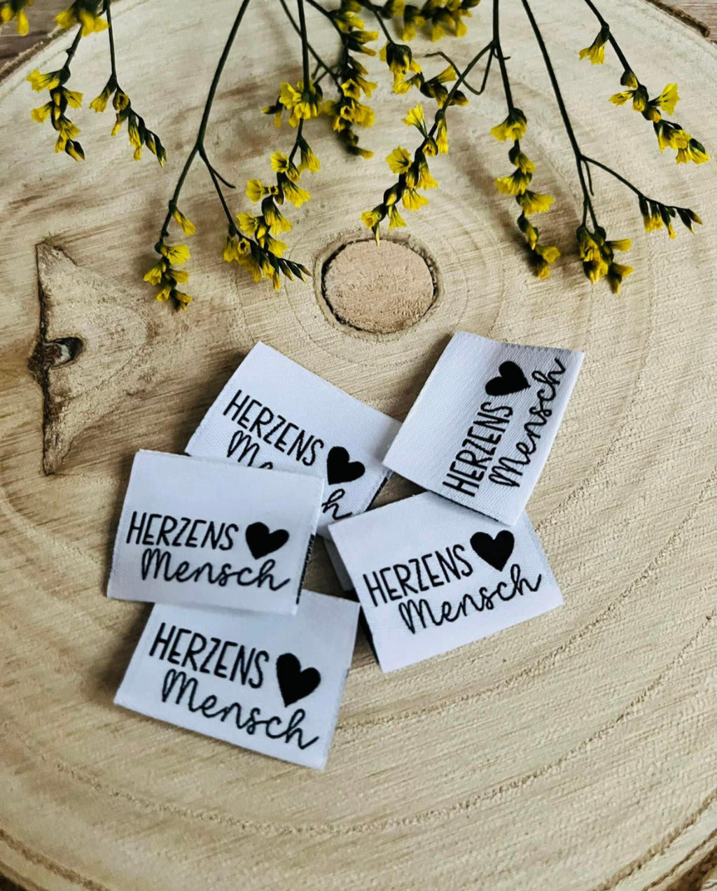 weisses Weblabel mit der Aufschrift Herzensmensch und einem kleinen Herzen in Schwarzer Schrift