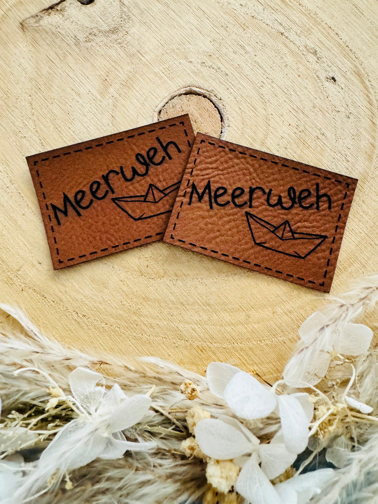 superweiches braunes Kunstlederlabel mit dem Spruch Meerweh und einem kleinen Papierschiffchen