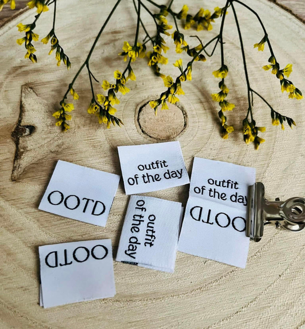 weisses Weblabel mit den Sprüchen OOTD und Outfit of the day in schwarzer Schrift