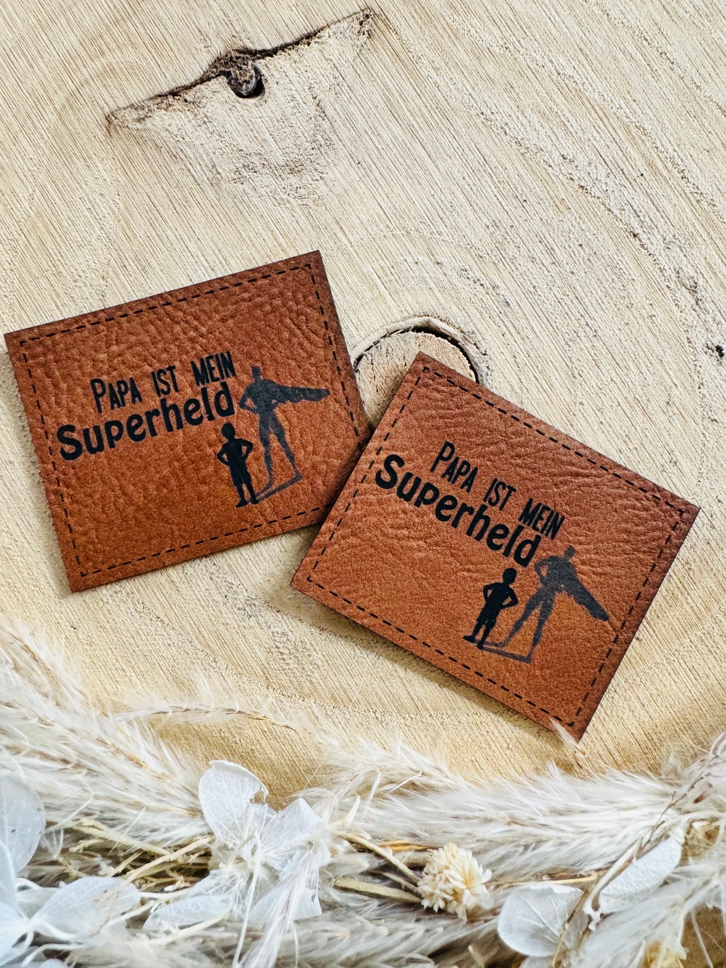 braunes Kunstleder Label mit dem Spruch Papa ist mein Superheld und der Abbildung eines Kindes mit seinem Superhelden-Papas