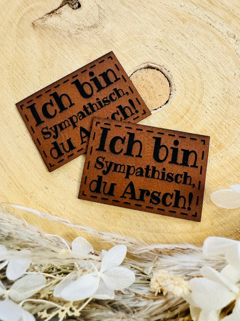superweiches braunes Kunstlederlabel mit dem pruch Ich bin sympatisch du Arsch Ausrufezeichen