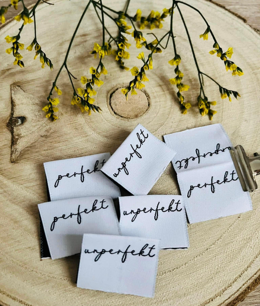 weisses Weblabel mit dem Spruch perfekt unperfekt in schwarzer Schrift