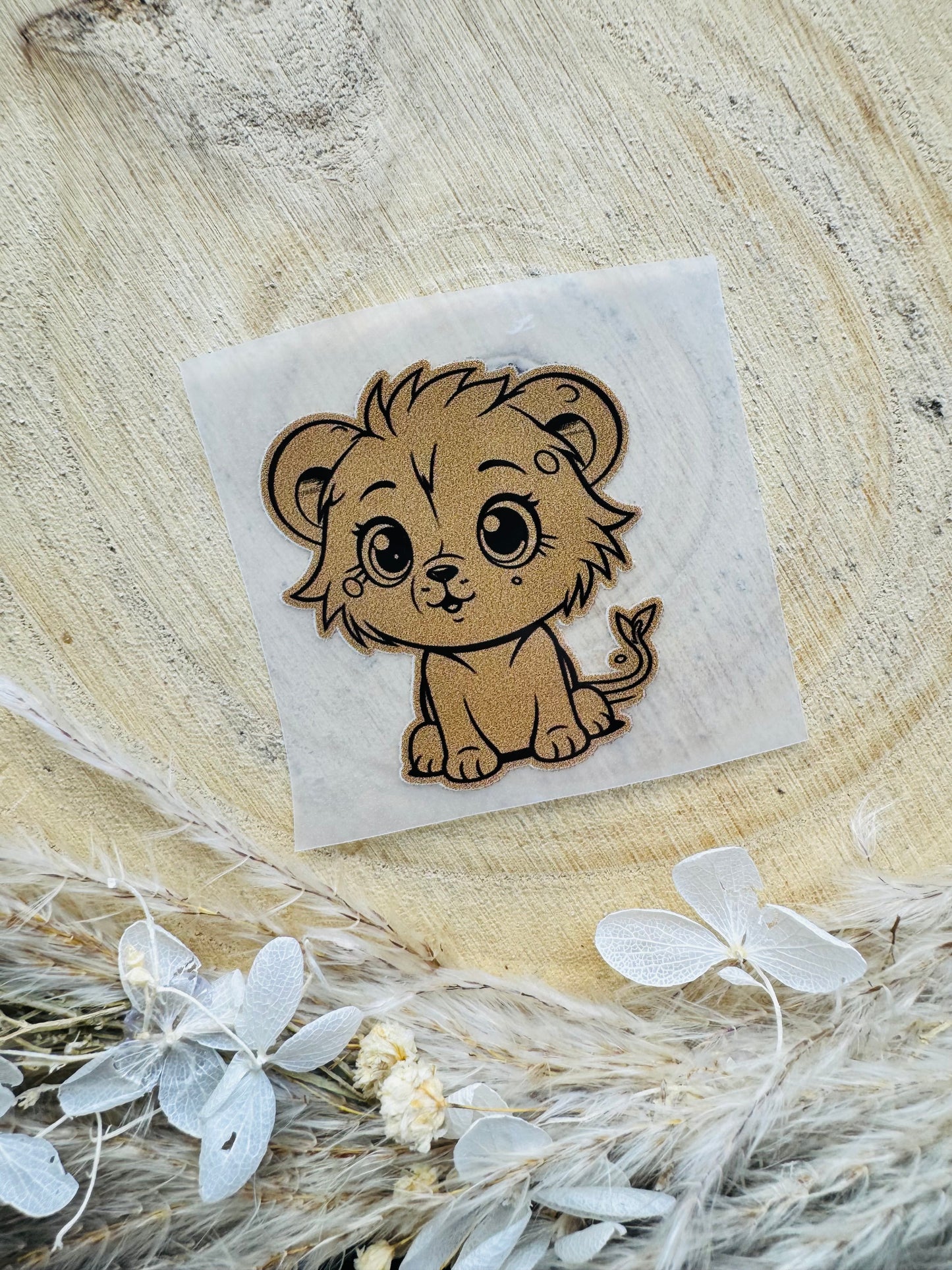 braunes Bügellabel Etikett mit einem kleinen sitzenden Löwenbaby