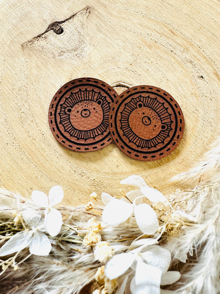 superweiches braunes rundes kunstlederlabel mit einem kleinen Loewengesicht