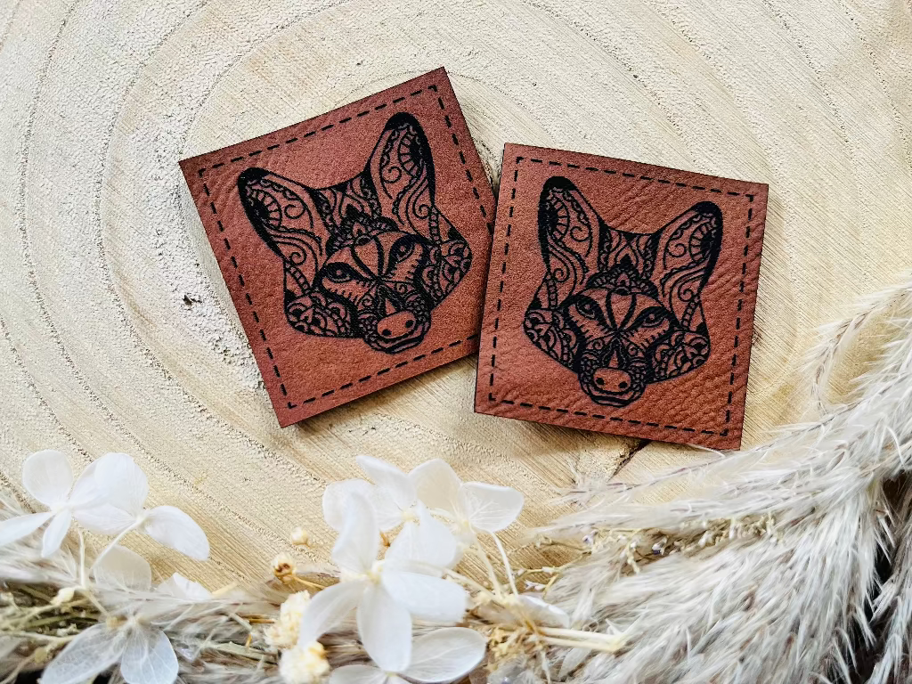 braunes Kunstlederlabel mit einem gezeichneten Wolfskopf in schwarz