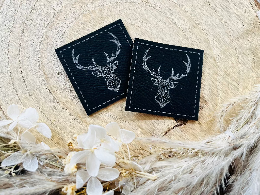 schwarzes kunstlederlabel mit einem hirsch kopf abgebildet