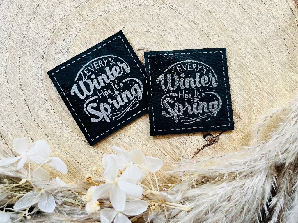 schwarzes weiches Kunstleder Label mit dem Spruch Every Winter has ItsSpring in schöner silberner Schrift