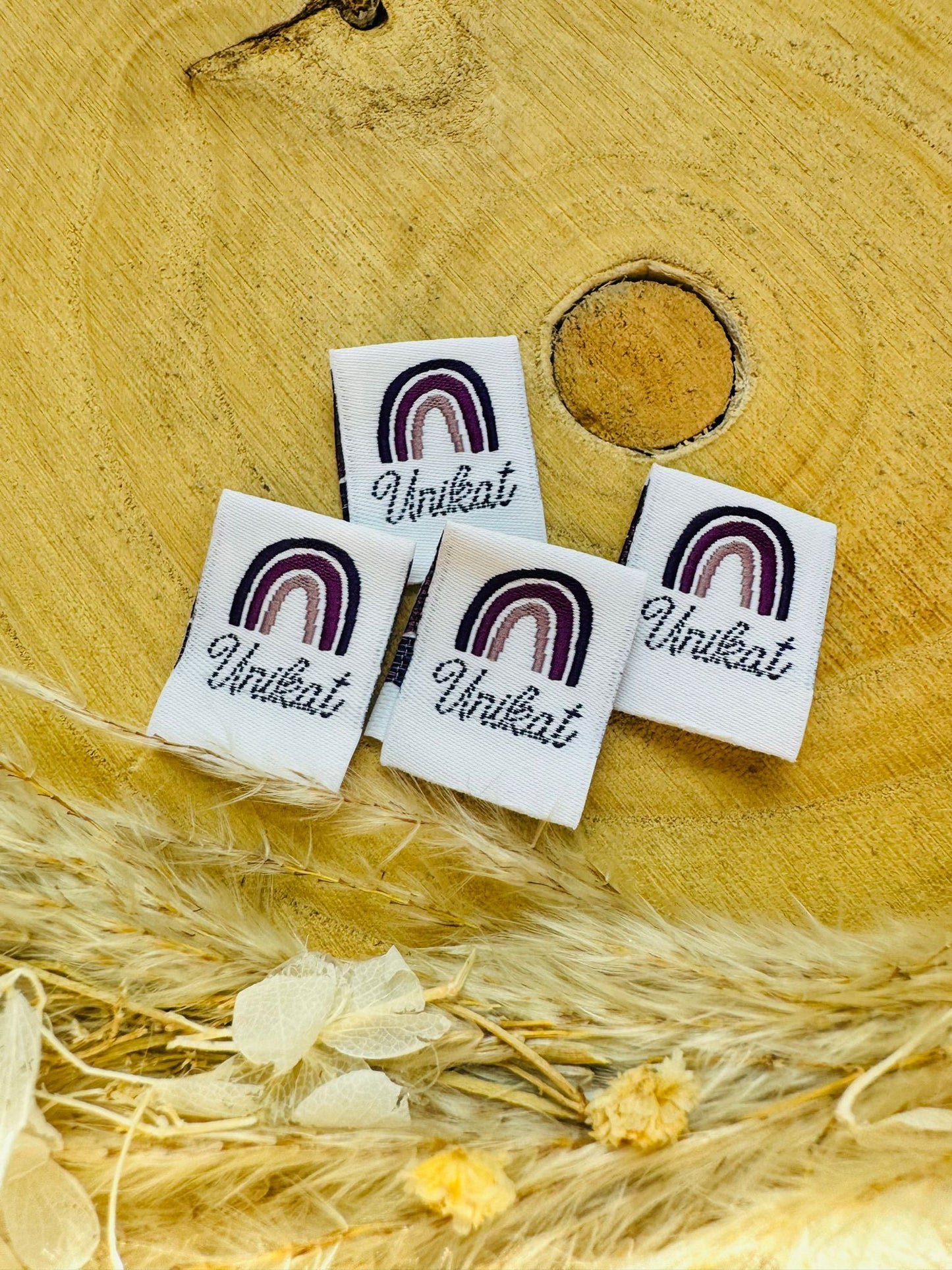weisses Weblabel mit einem regenbogen in violetten Farben und dem Spruch Unikat