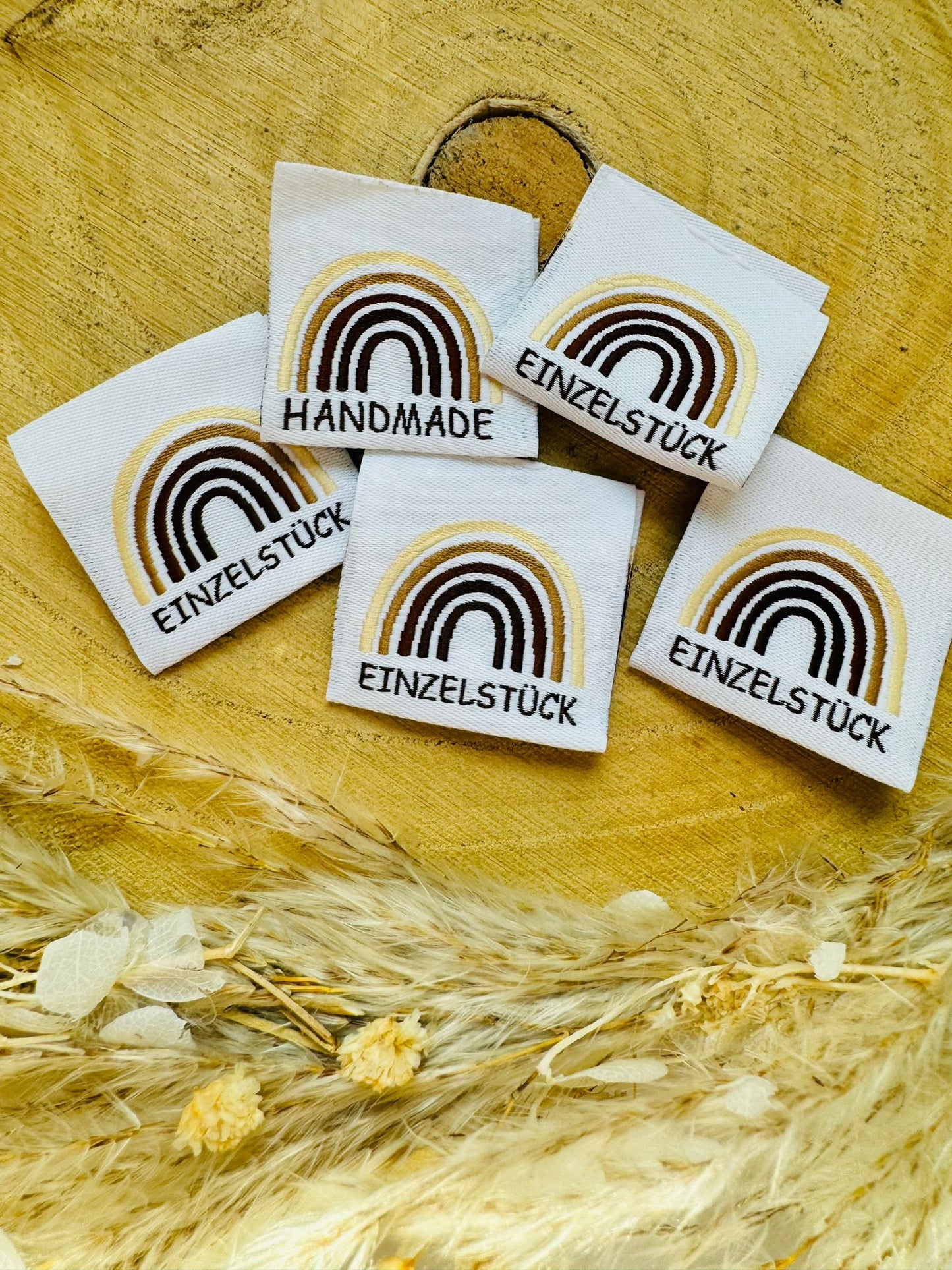 weisses Weblabel mit einem Regenbogen in verschiedenen Brauntönenund dem Spruch Einzelstück und Handmade