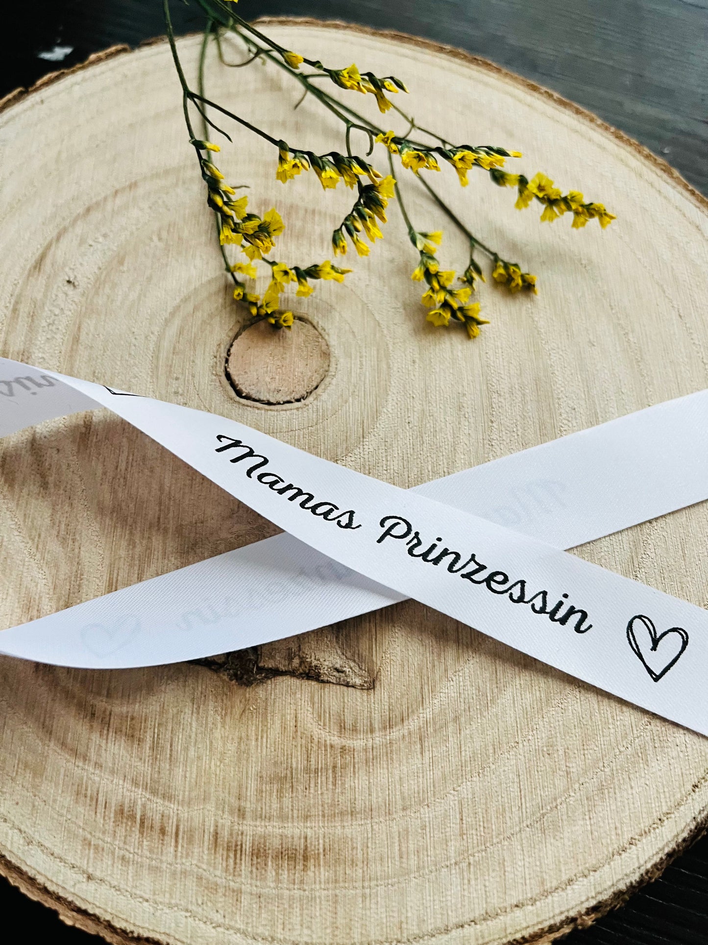 weisses Satinband mit dem fortlaufenden Spruch Mamas Prinzessin und kleinen Herzen