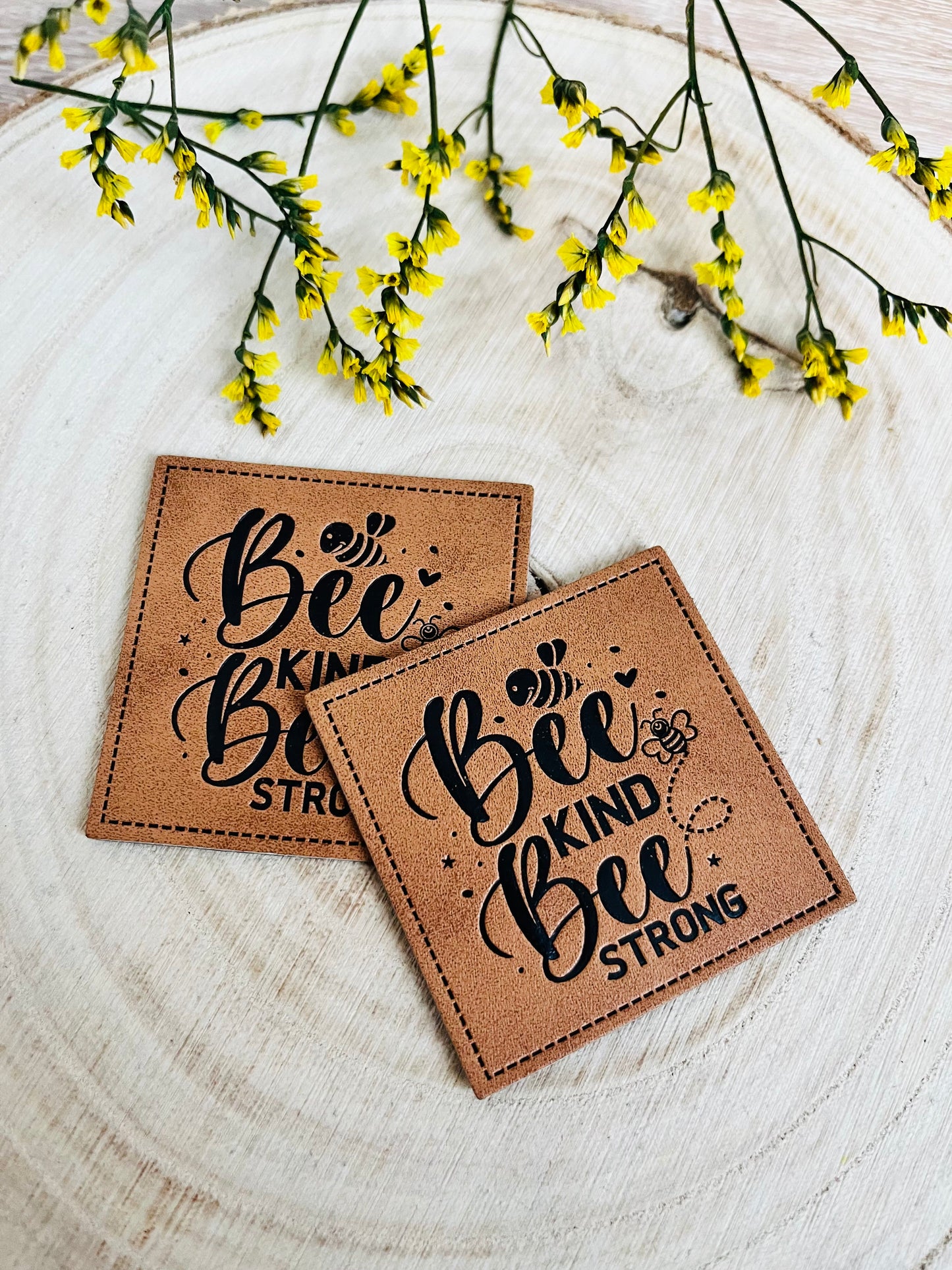 braunes kunstlederlabel mit dem spruch bee kind bee strong und kleinen bienchen abgebildet