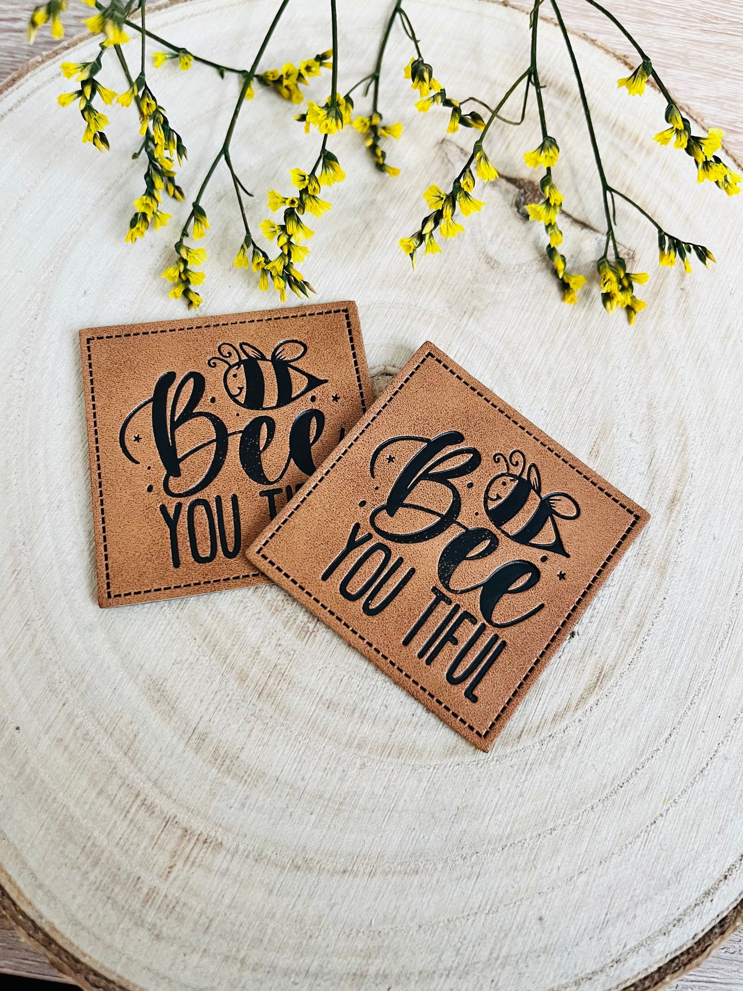 braunes kunstlederlabel mit dem spruch bee you tiful und einer kleinen biene abgebildet
