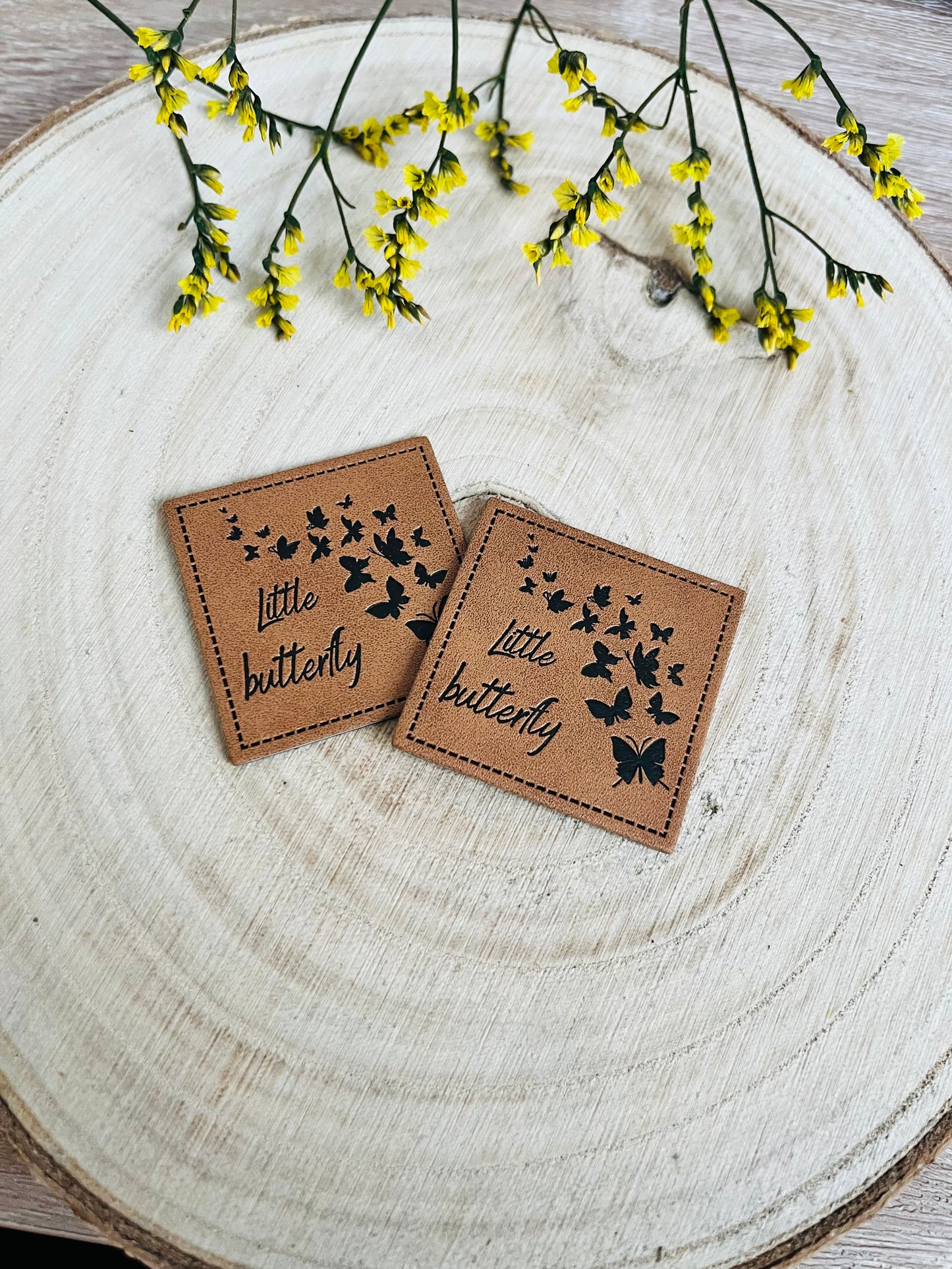 braunes Kunstlederlabel mit dem Spruch little Butterfly und kleinen Schmetterlingen