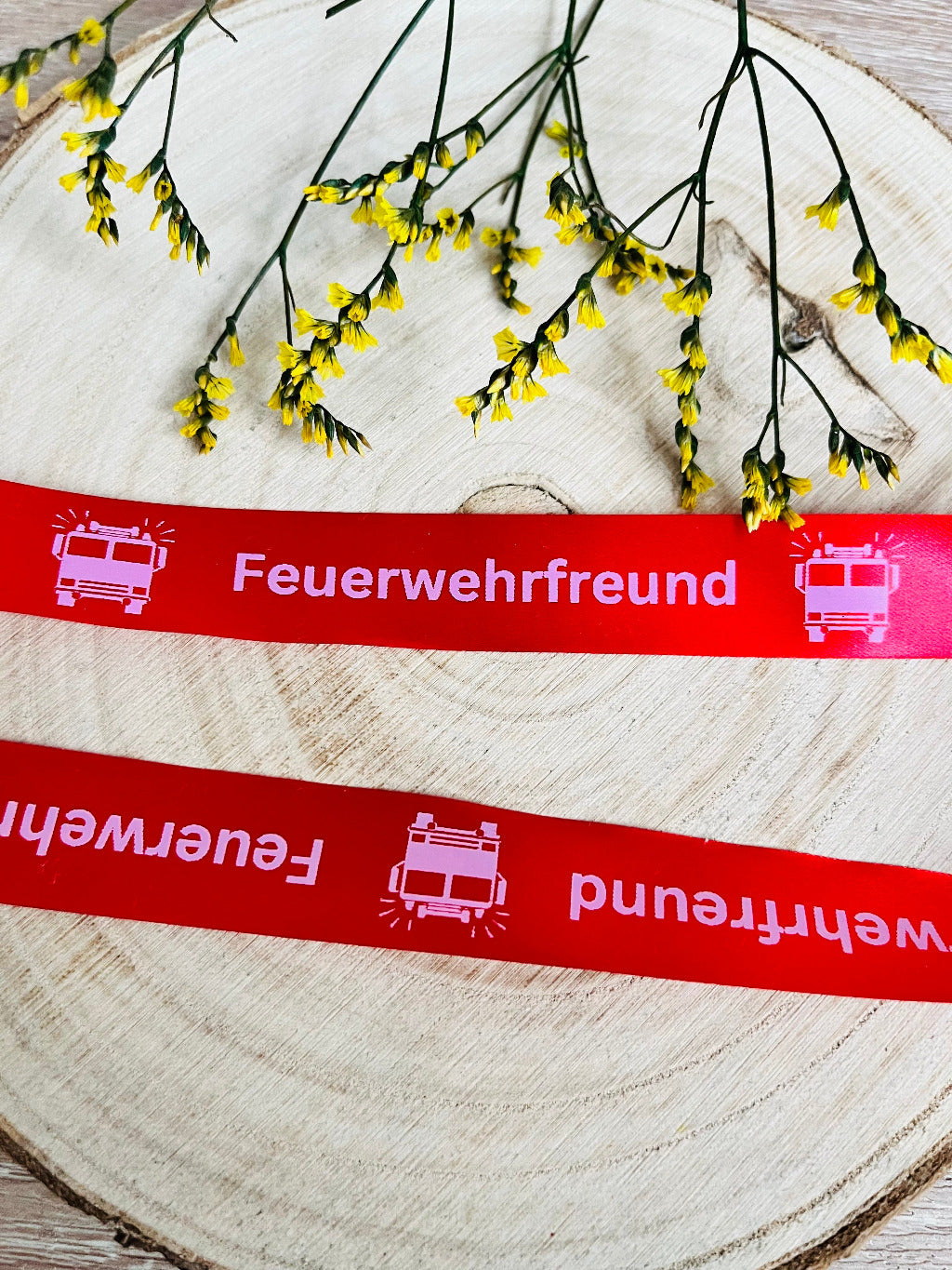 schönes rotfarbenes Satinband mit dem fortlaufenden Spruch Feuerwehrfreund und einer Feuerwehr abgebildet, Breite 2 Zentimeter.