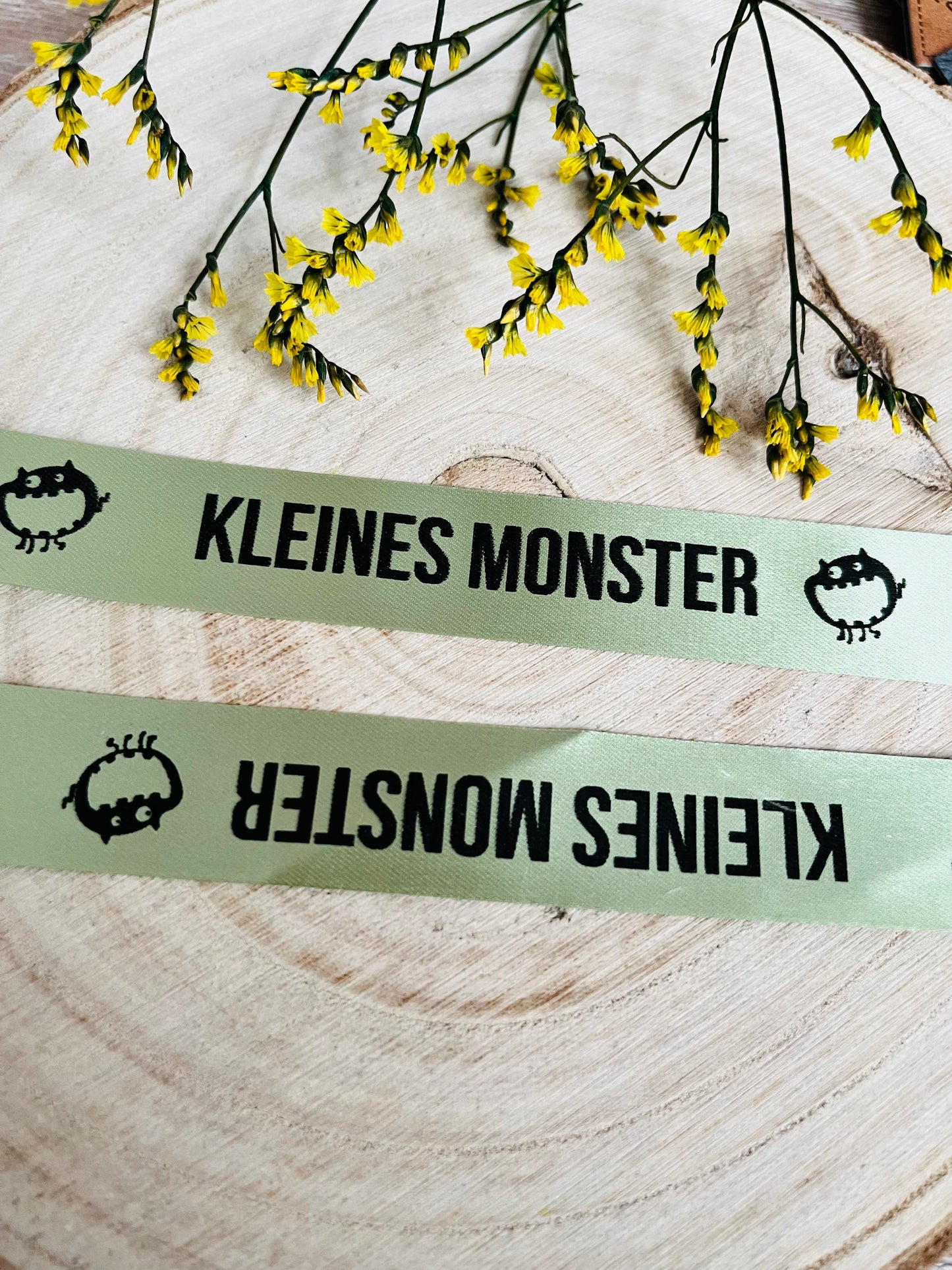 hellgrünes Satinband mit dem fortlaufenden Spruch Kleines Monster