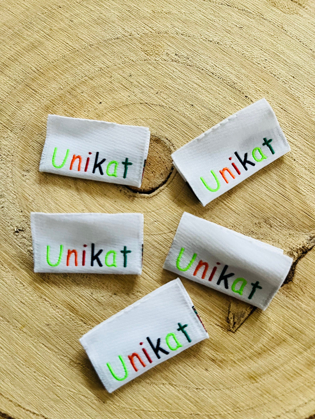 weisses Weblabel mit dem Spruch Unikat in bunten Buchstaben