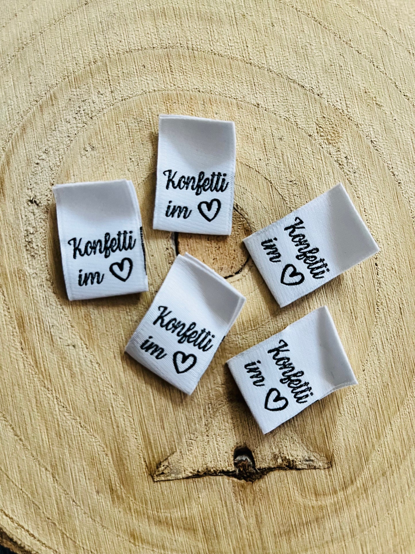 weisses Weblabel mit dem Spruch Konfetti im und einem herzsymbol in schwarz