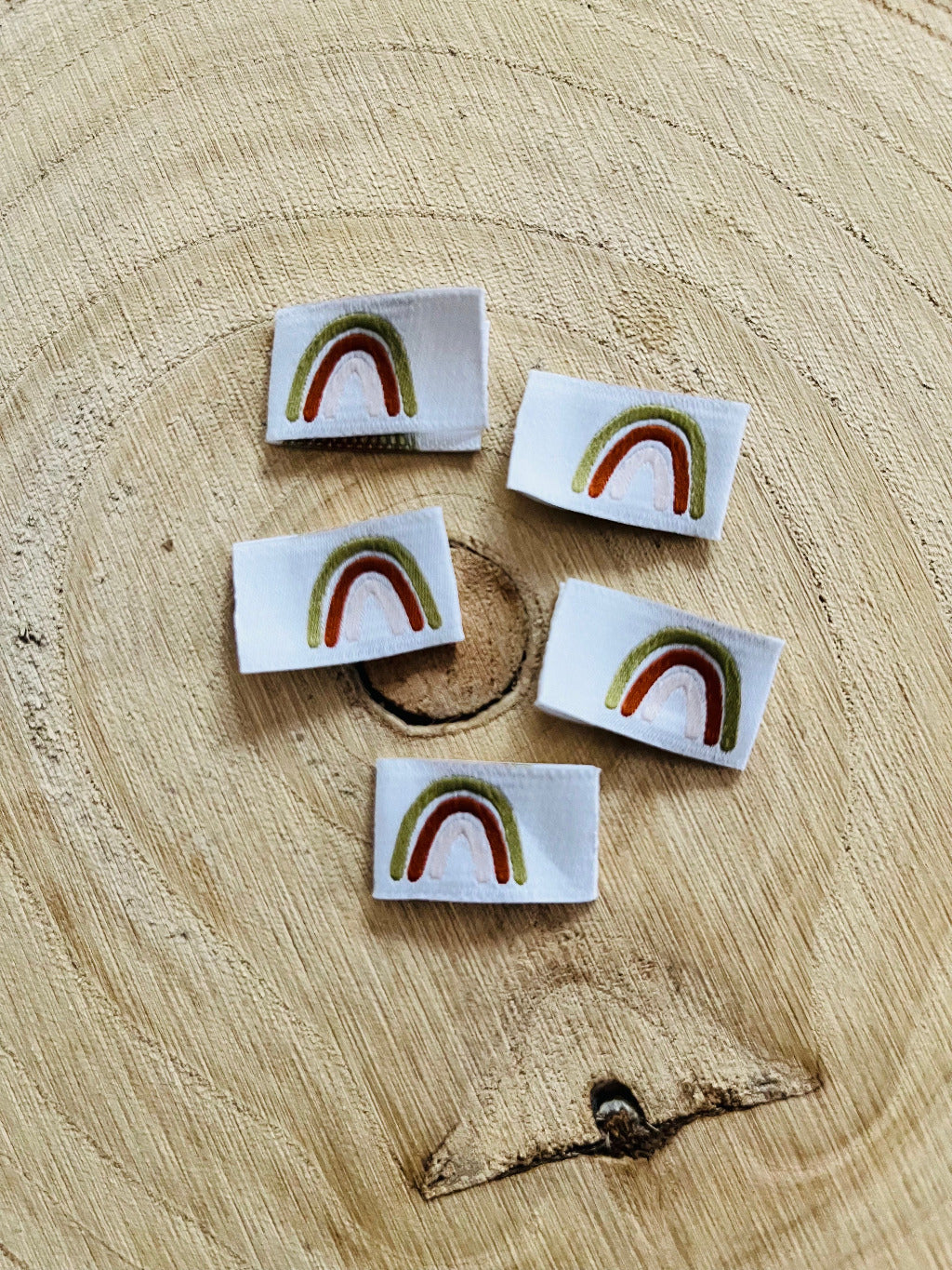 weisses Weblabel mit einem Regenbogen in goldener und bronzener Farbe