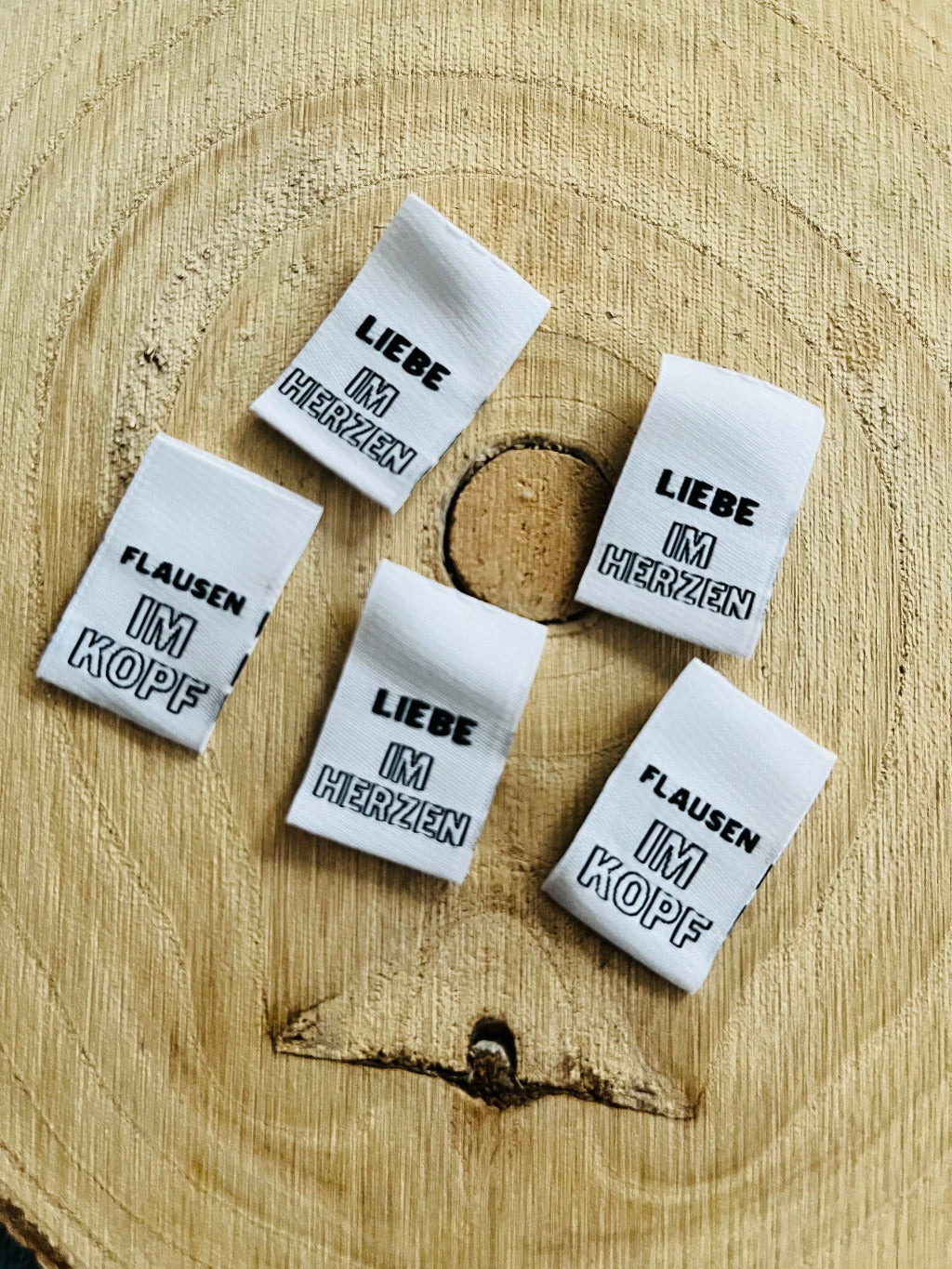 weisses Weblabel mit Aufschrift Liebe im Herzen und Flausen im Kopf in schwarzer Schrift