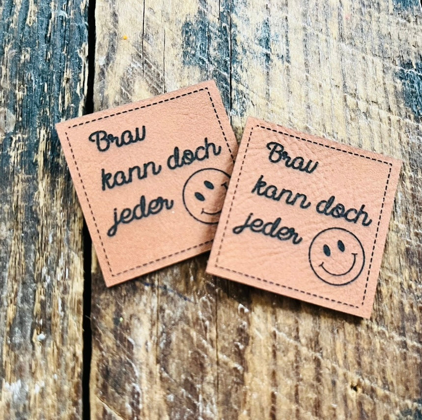 braunes Kunstlederlabel mit dem Spruch Brav kann doch jeder und einem Smiley