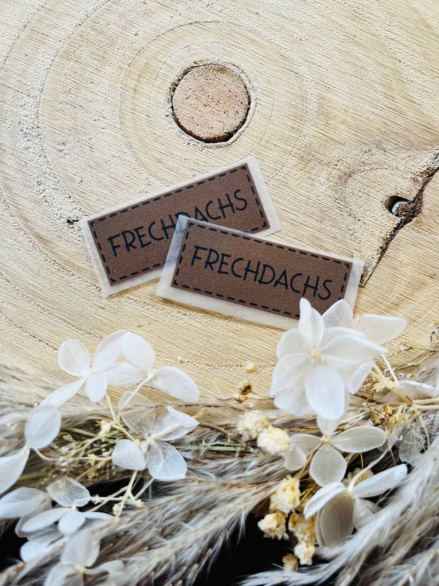 braunes Bügellabel mit dem Spruch Frechdachs