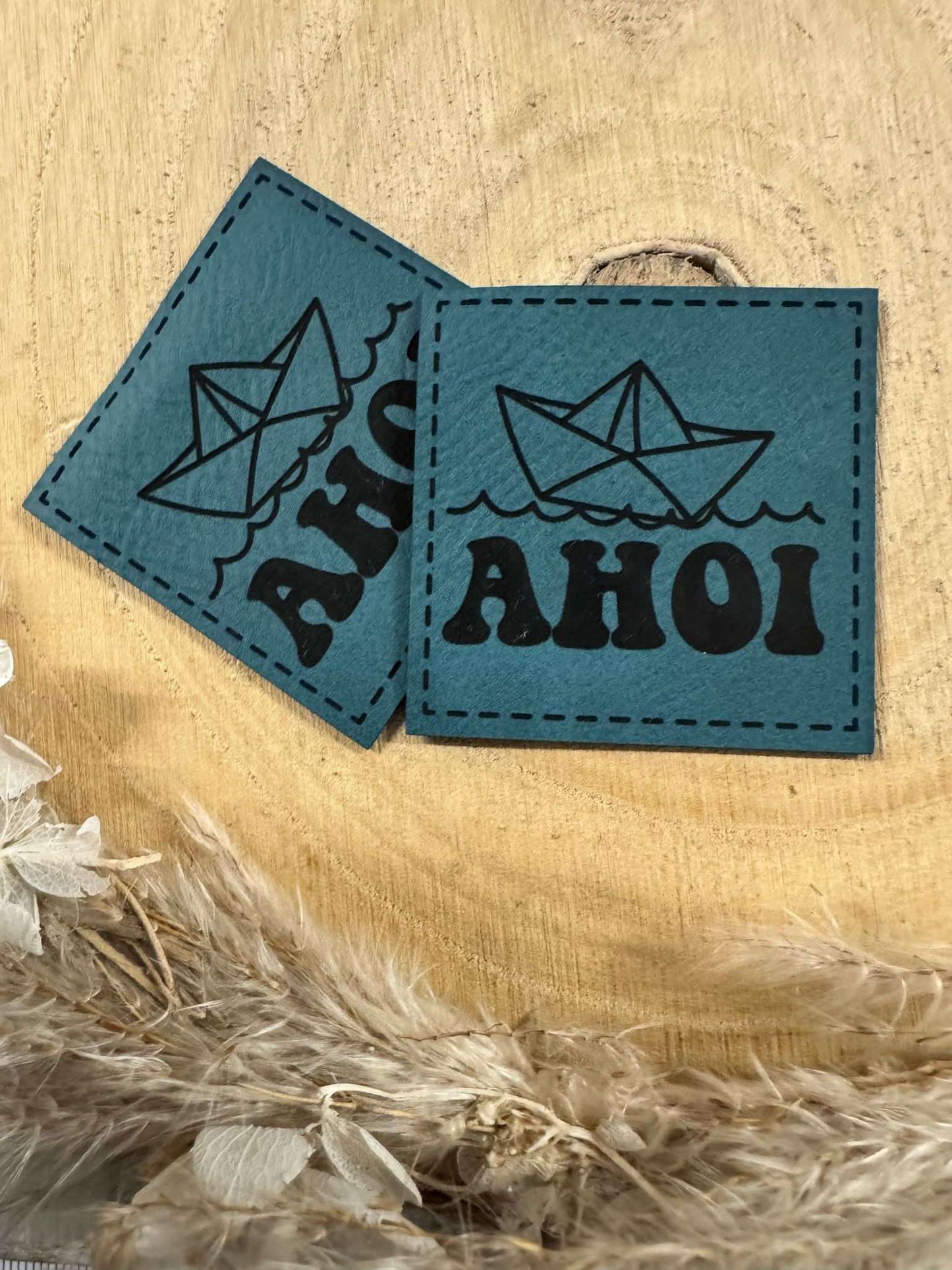 exclusives superweiches Kunstlederlabel in Türkis mit dem Spruch AHOI und einem kleinen Papierboot auf See