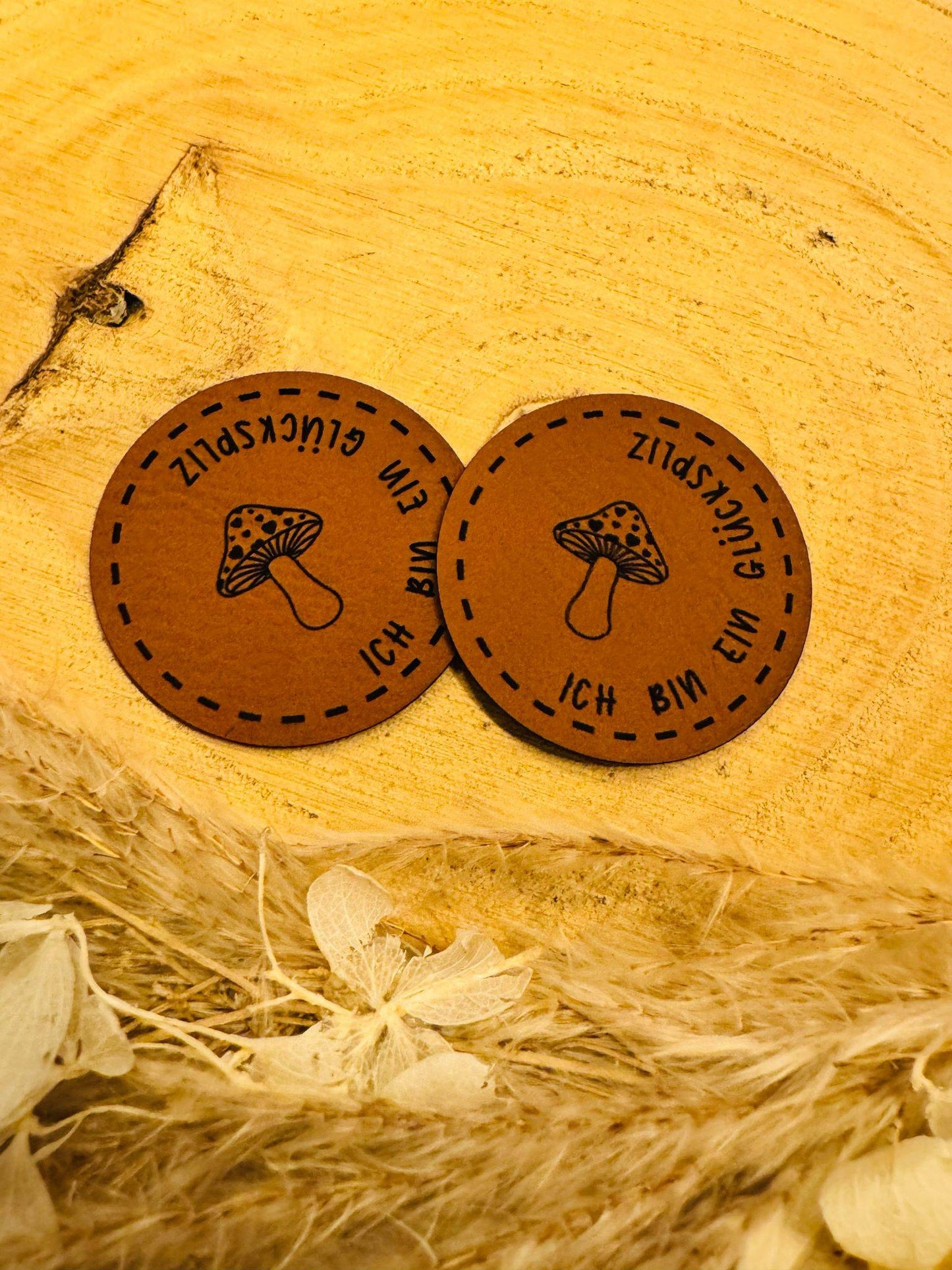 superweiches rundes braunes Kunstlederlabel mit einem Pilz und dem Spruch Ich bin ein Glückspilz