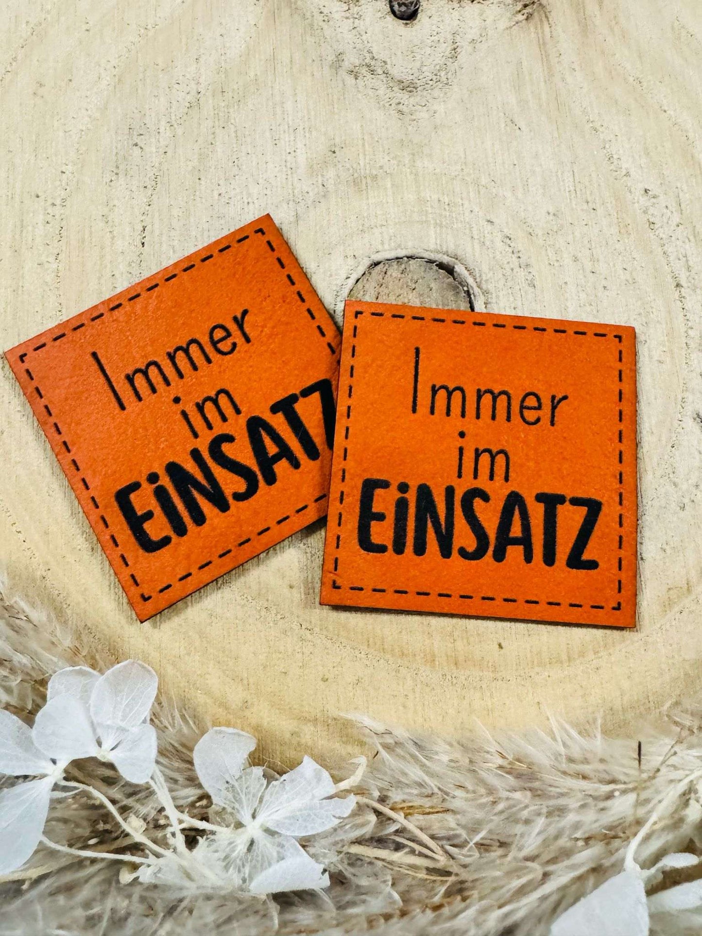 exclusives superweiches orangenes Kunstlederlabel mit dem Spruch Immer im Einsatz