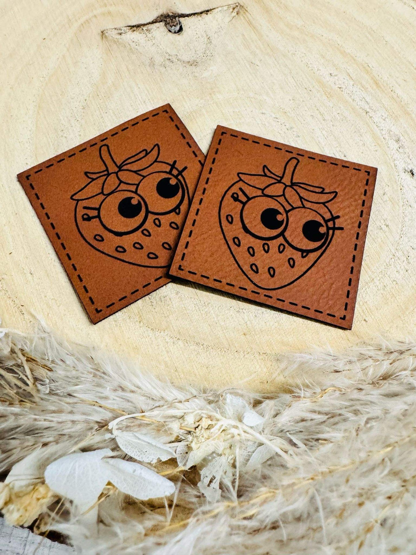 superweiches braunes Kunstlederlabel mit einer frechen Erdbeere abgebildet