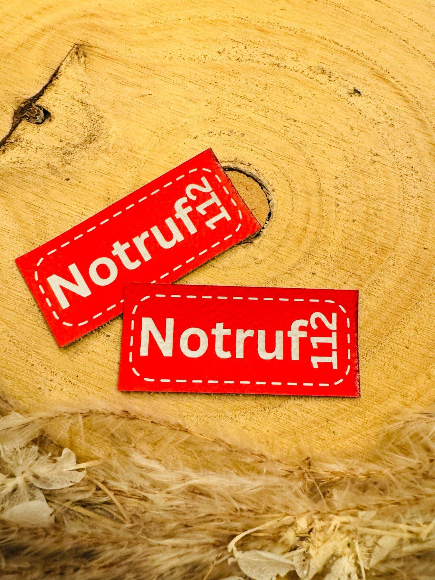 exclusives farbiges Kunstlederlabel in Rot mit dem Spruch Notruf 112