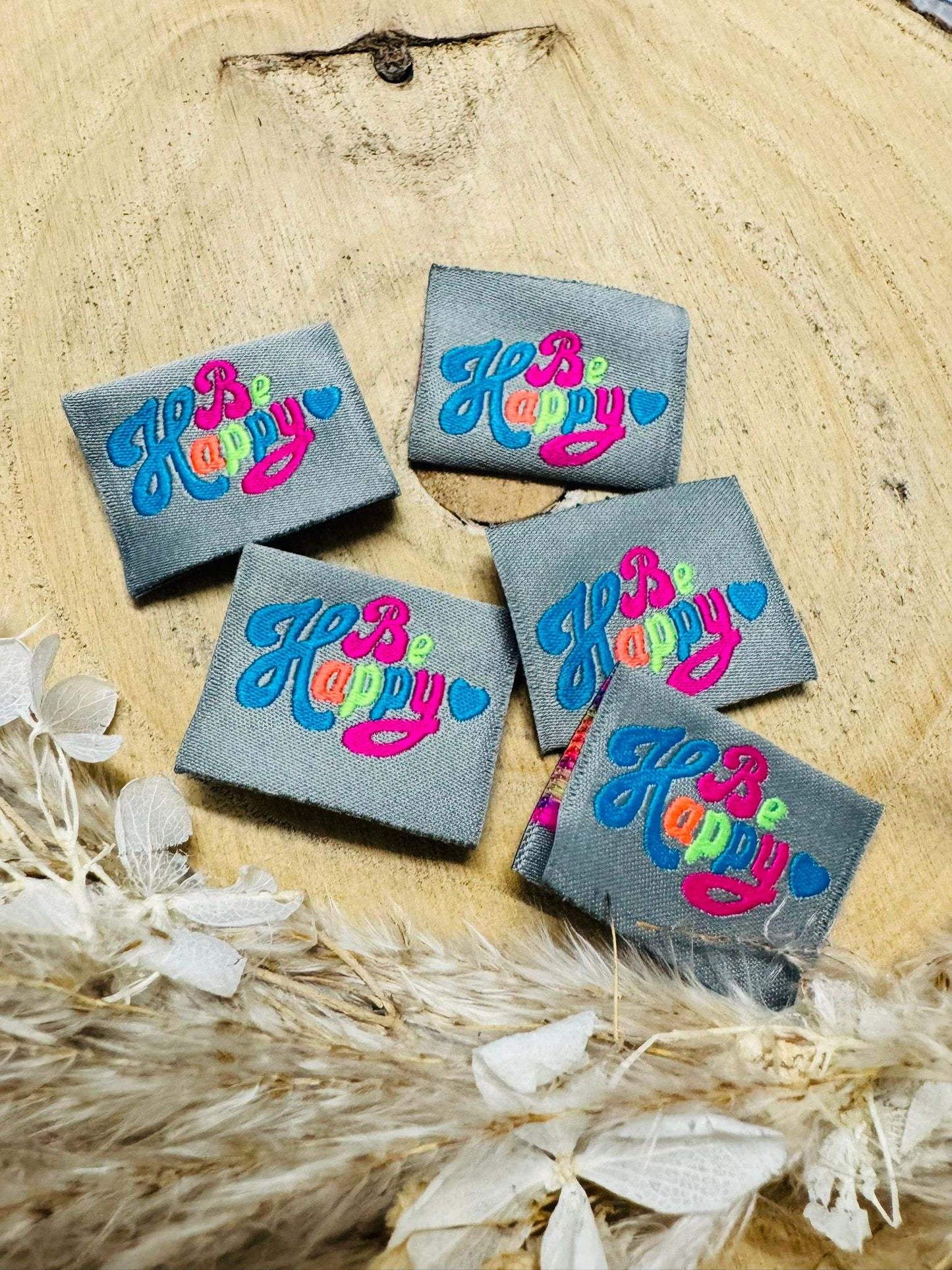 tolles graues Weblabel mit dem Spruch Be Happy in bunten Buchstaben und einem kleinen Herzchen