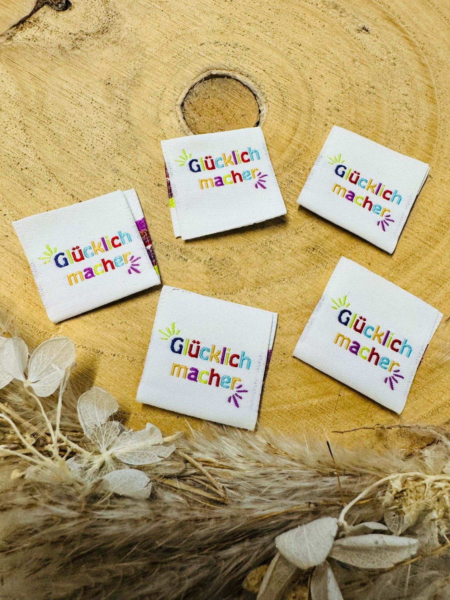 exclusives weisses Weblabel mit dem Spruch Gluecklichmacher in bunter Schrift