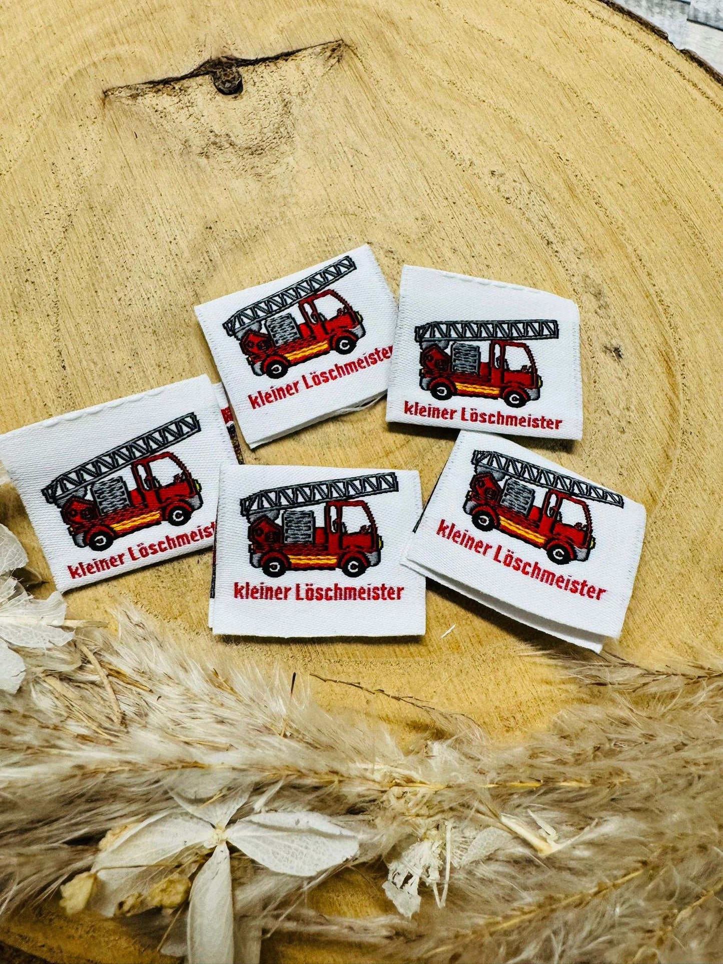 tolles weisses Weblabel mit einer kleinen Feuerwehr und dem Spruch Kleiner Loeschmeister abgebildet