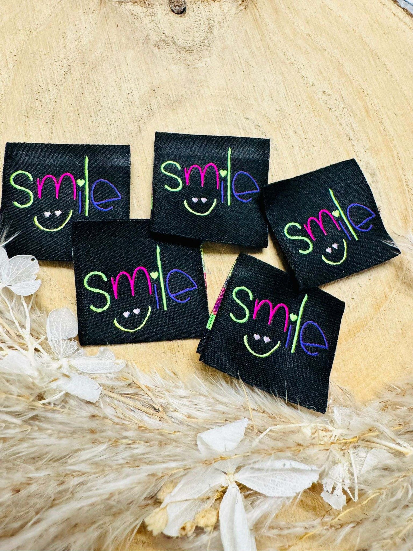 tolles schwarzes Weblabel mit dem Spruch Smile in bunten Buchstaben mit einem kleinen Smiley abgebildet