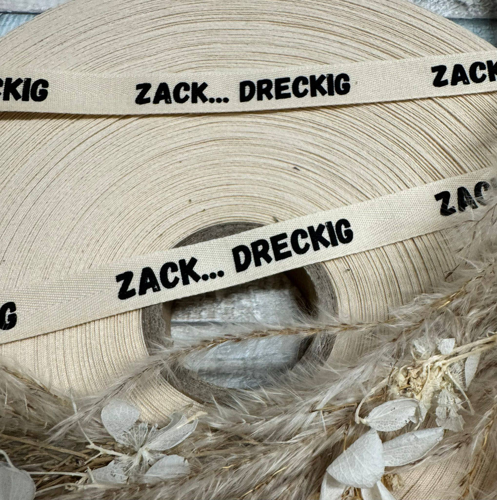 schönes weisses Flach Baumwoll Webband mit dem Spruch Zack...Dreckig