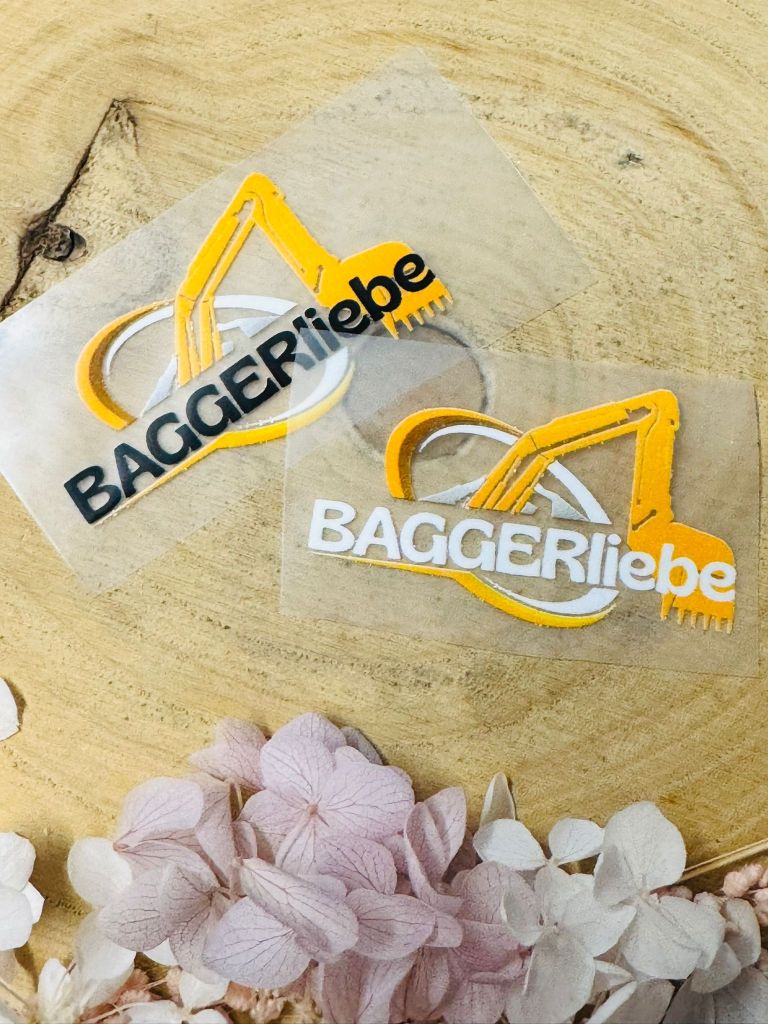 aufbügelbares Label mit dem Spruch Baggerliebe und einem gelben Bagger abgebildet in schwarz und weisser Ausführung