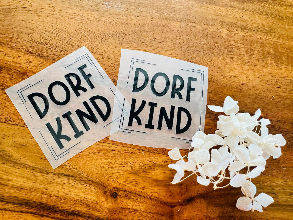 tolles Bügellabel mit dem Spruch Dorf Kind in schwarzen Buchstaben
