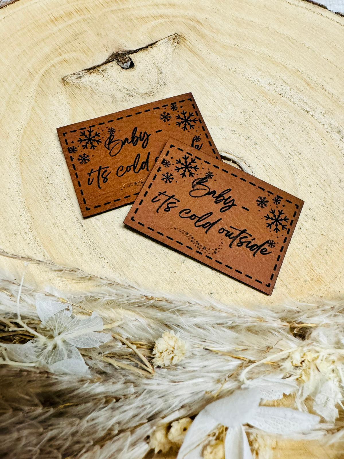 braunes kunstlederlabel mit dem spruch baby its cold outside